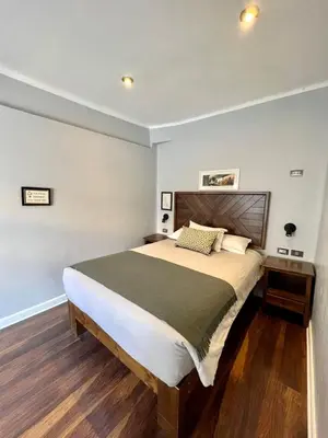 a bedroom with a large bed with a wooden headboard at Casa Montes San Blas in Cusco