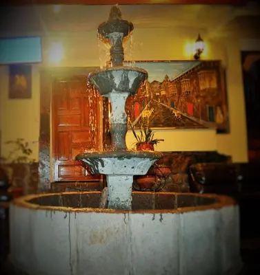 a water fountain in a room with a painting at Hotel Choquequirao in Cusco