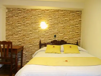 a bedroom with a bed with a stone wall at Hotel Choquequirao in Cusco