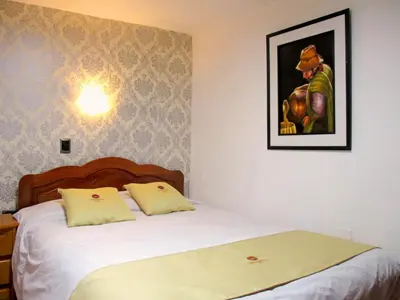 a bedroom with a bed and a picture on the wall at Hotel Choquequirao in Cusco