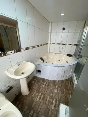 a bathroom with a tub and a sink and a toilet at Hostal Milagros in Chancay
