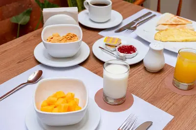 a table with plates of food and a glass of milk at Equo Hotel Boutique in Lima