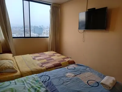a hotel room with two beds and a flat screen tv at apartamento CAA pardo in Lima