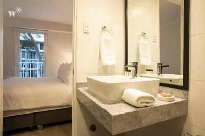 a bathroom with a sink and a bed and a mirror at Osma by Wynwood House in Lima