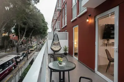 a balcony with tables and chairs on a city street at Osma by Wynwood House in Lima