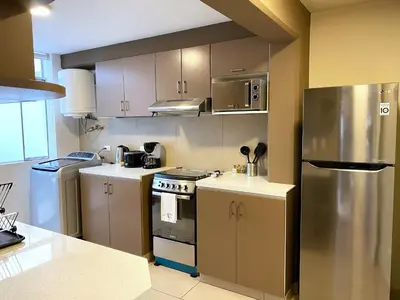 a kitchen with a stainless steel refrigerator and white cabinets at Nomad By Wynwood House in Lima