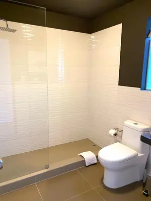 a bathroom with a toilet and a glass shower at Nomad By Wynwood House in Lima