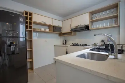 a kitchen with a sink and a black refrigerator at Nomad By Wynwood House in Lima