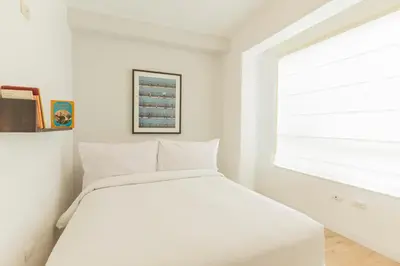 a white bedroom with a bed and a window at Nomad By Wynwood House in Lima