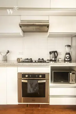 a kitchen with a stove and a microwave at Las Mimosas by Wynwood House in Lima
