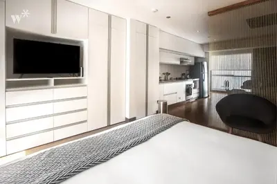 a bedroom with a bed with a television and a chair at Las Mimosas by Wynwood House in Lima