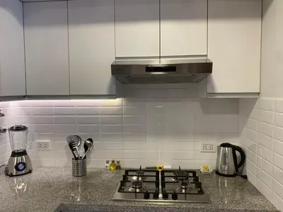 a kitchen with white cabinets and a stove top oven at Las Mimosas by Wynwood House in Lima