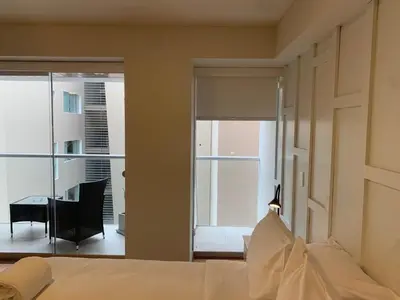 a bedroom with a bed and a desk and a window at Las Mimosas by Wynwood House in Lima