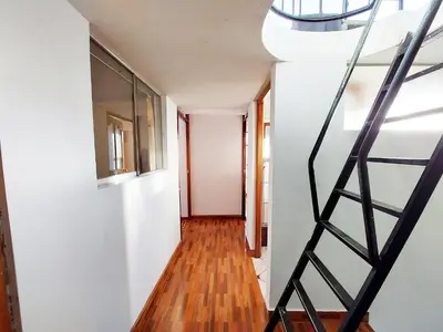 a staircase in a house with white walls and wood floors at Casa Mirador Cristo Blanco, Great view of Cusco in Cusco
