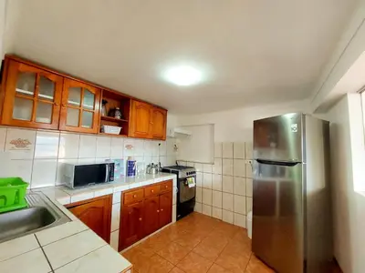 a kitchen with wooden cabinets and a stainless steel refrigerator at Casa Mirador Cristo Blanco, Great view of Cusco in Cusco