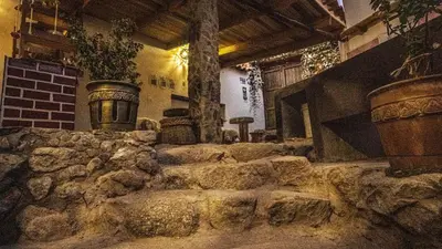 a room with a stone wall and some vases at MAMA GREEN HOSTAL - Eco Andean Experience and Permaculture Farm - Vegetarian Breakfast in Urubamba