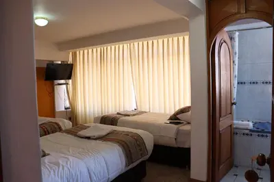 a hotel room with two beds and a window at Casa del Escultor in Cusco