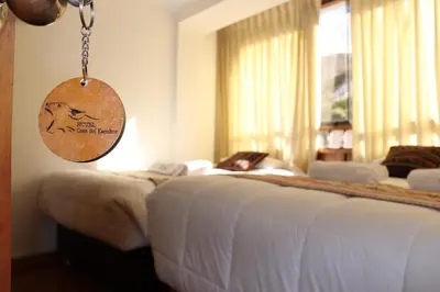 a hotel room with two beds and a sign on the wall at Casa del Escultor in Cusco