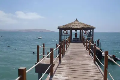 a wooden pier with a gazebo on the water at PARACAS megaview bayfront flat in Paracas