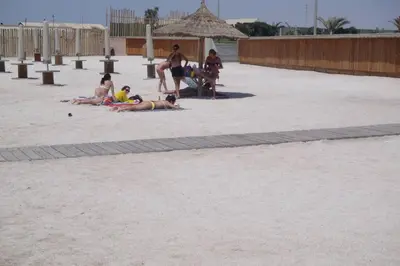 a group of people laying on the sand on the beach at PARACAS megaview bayfront flat in Paracas