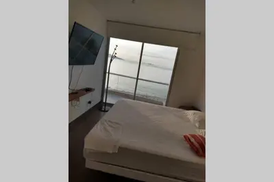 a bedroom with a bed and a large window at PARACAS megaview bayfront flat in Paracas