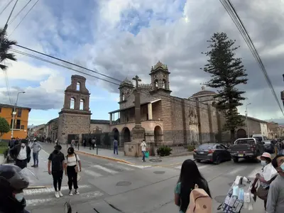 a group of people crossing a street in front of a building at HOSPEDAJE CENTRAL in Ayacucho