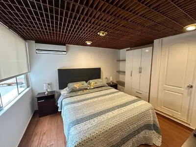 a bedroom with a bed with a comforter on it at 2- Amplio Departamento remodelado en Miraflores in Lima
