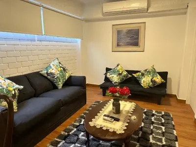 a living room with a black couch and a table at 2- Amplio Departamento remodelado en Miraflores in Lima