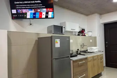 a kitchen with a refrigerator and a tv on the wall at 4B Mini-departamento nuevo en centro de Miraflores in Lima