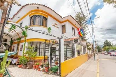 a yellow and white building on a street at Hotel Campanario in Cusco