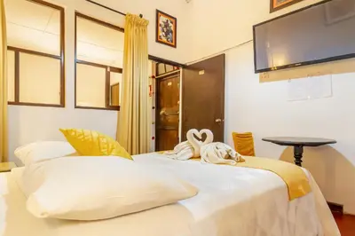 two white beds in a room with a tv at Hotel Campanario in Cusco