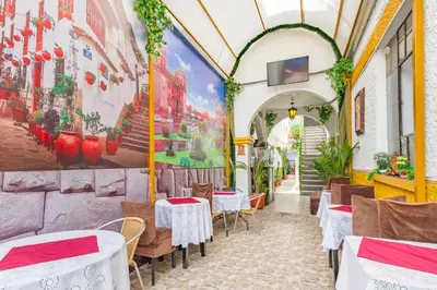 a restaurant with tables and chairs and a painting on the wall at Hotel Campanario in Cusco