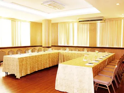 a conference room with long tables and chairs and windows at Kingdom Hotel in Lima
