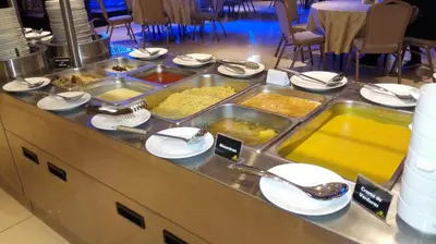 a buffet line with many trays of food at Kingdom Hotel in Lima