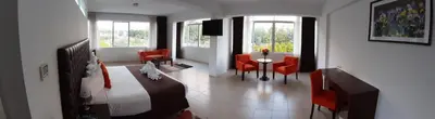 a bedroom with a bed and a table and chairs at Guizado Portillo Hacienda & Resort in Lunahuaná