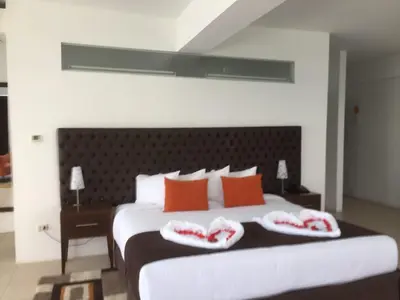 a bedroom with a large bed with red pillows at Guizado Portillo Hacienda & Resort in Lunahuaná
