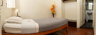 a bedroom with a bed with a vase of flowers at Hospedaje Santa Rosa- Centro Histórico in Lima