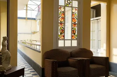 a hallway with a chair and stained glass windows at Hospedaje Santa Rosa- Centro Histórico in Lima