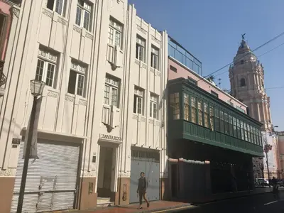 a man walking down a street in front of buildings at Hospedaje Santa Rosa- Centro Histórico in Lima