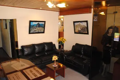 a living room with leather couches and a woman at Hostal Alfredo's Palace in Cusco