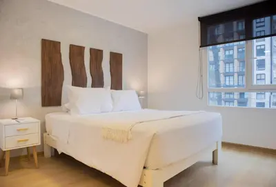 a bedroom with a large white bed with a window at Martinto 114 by Wynwood House in Lima