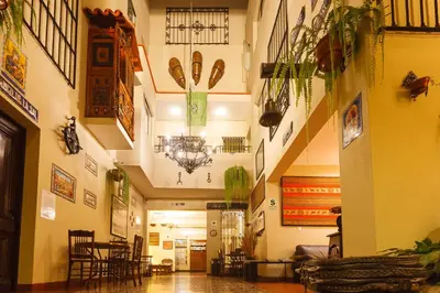 a hallway with tables and chairs and a chandelier at Casa Suyay in Lima