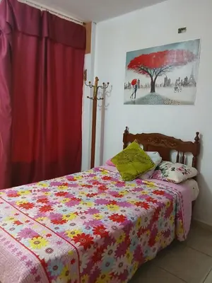 a bedroom with a bed with a colorful comforter at Inti Hostel Airport in Lima