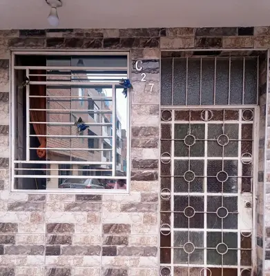 a front door of a building with a dog in the window at Inti Hostel Airport in Lima