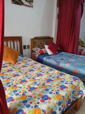 a bedroom with two beds with a quilt on it at Inti Hostel Airport in Lima