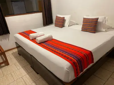 a large bed with two towels on top of it at Quipu Hostal in Machu Picchu