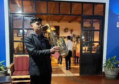 a man playing a saxophone in a room at La Estancia Chincha Hotel in Chincha Alta