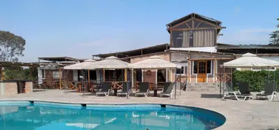 a resort with a swimming pool in front of a building at Huaranjapo in El Carmen