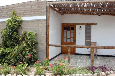 a small house with a wooden door and some flowers at Huaranjapo in El Carmen