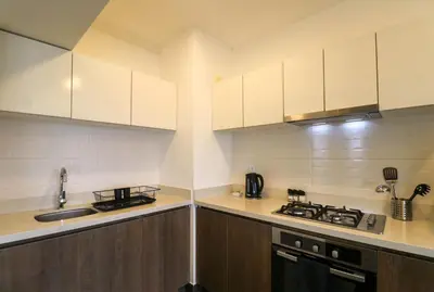 a kitchen with white cabinets and a stove top oven at Reducto 825 by Wynwood House in Lima